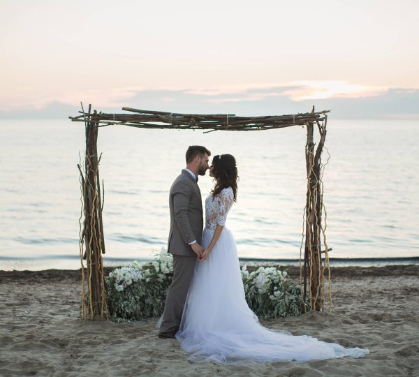 Luxury Wedding Package at Magic Ocean Resort the bride and groom under archway on beach sunset 2024 08 08 05 56 12 utc 1 600x540